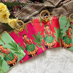 May include: Four colorful fabric pouches with gold handles and beaded embellishments. Each pouch features a green and gold illustration of a woman in a traditional Indian outfit.