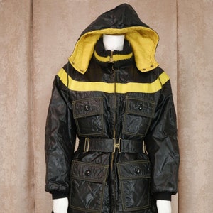 May include: A black hooded jacket with a yellow stripe across the chest and a belt. The jacket has multiple pockets and is lined with a yellow fabric.