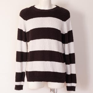 May include: A brown and white striped sweater with a crew neck. The sweater has thick horizontal stripes and long sleeves. The garment is displayed on a mannequin against a white background. The sweater is a casual style.
