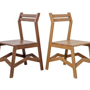 May include: Two wooden chairs with a minimalist design. One chair is a dark brown, the other is a light brown. Both chairs have a square seat, angled legs, and a back with two horizontal slats.