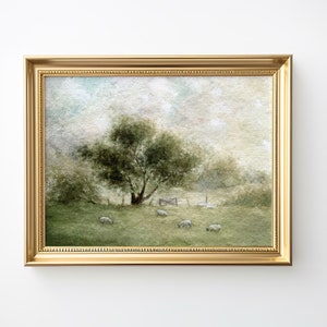 Könnte beinhalten: Ein gerahmtes Aquarellbild, das eine ländliche Szene mit einem grünen Baum im Vordergrund und Schafen darstellt, die auf einer Weide grasen. Der Himmel ist hellblau mit weißen Wolken.