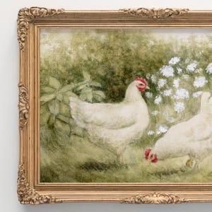 May include: A framed painting depicts two white chickens in a grassy field with white flowers and green foliage. The ornate gold frame adds a classic touch to the artwork, enhancing the pastoral scene.