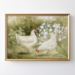 May include: A framed print featuring two white chickens in a garden setting. The chickens have red combs and are surrounded by green foliage and white flowers. The artwork is set in a gold-colored frame.