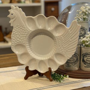 Op de afbeelding: Een witte keramische mok met een zwart handvat en de tekst "But First, Coffee" in een zwarte, vette letter. De mok staat op een houten oppervlak.