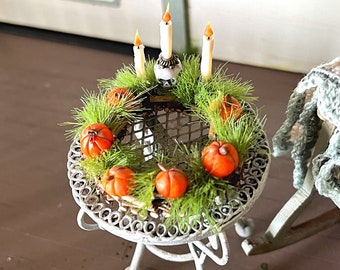 Wooden wreath with pumpkins, skull and candles for decoration in the dollhouse