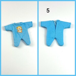 Puede incluir: Un pelele azul para beb&eacute; con un dise&ntilde;o de osito de peluche. El pelele tiene una cremallera y est&aacute; hecho de un tejido suave y el&aacute;stico.