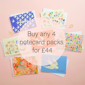 Peut inclure: Assortiment de cinq paquets de cartes de vœux avec différents motifs floraux et d'oiseaux. Les cartes sont toutes blanches avec un fond bleu, vert ou rose. Le texte "Buy any 4 notecard packs for £44" est écrit dans un cercle blanc au-dessus des cartes.