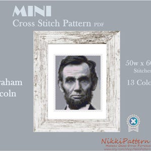 May include: A black and white cross stitch pattern of Abraham Lincoln's portrait in a white frame. The pattern is 50 stitches wide by 60 stitches high and uses 13 colours.