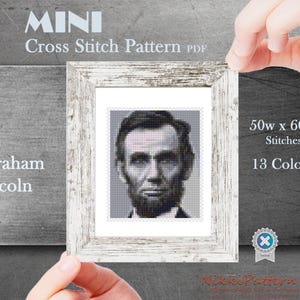May include: A cross stitch pattern of Abraham Lincoln's portrait in black and white. The pattern is 50 stitches wide by 60 stitches high and uses 13 colours.