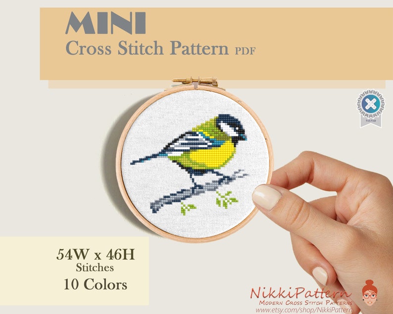 A cross stitch pattern of a yellow bird with black and blue markings perched on a branch. Mini cross stitch pattern.