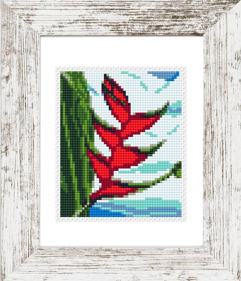 May include: Cross-stitch art of a red tropical flower with green leaves and blue water, framed in a white distressed wood frame. The artwork is a detailed pixelated image, perfect for home decor.