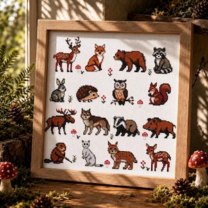 May include: A framed cross-stitch sampler featuring a grid of pixelated forest animals including a deer, fox, bear, raccoon, rabbit, hedgehog, owl, squirrel, moose, wolf, badger, boar, beaver, stoat, lynx, and fawn, accented with small red mushrooms.
