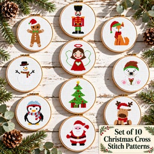 May include: A set of ten circular wooden embroidery hoops containing cross-stitch patterns of Christmas characters including a gingerbread man, nutcracker, fox, angel, snowman, polar bear, penguin, Christmas tree, reindeer, and Santa Claus.