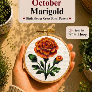May include: A cross stitch pattern featuring an orange and yellow marigold flower on white fabric, held in a 4-inch wooden hoop. The text reads October Marigold Birth Flower Cross Stitch Pattern and Ideal for 4 inch Hoop.