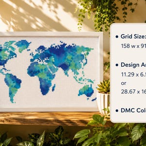 May include: A framed cross-stitch of a world map, featuring blue and green continents on a white background. The design area is 11.29 x 6.50 inches. The text on the right indicates the grid size, design area, and DMC colors.