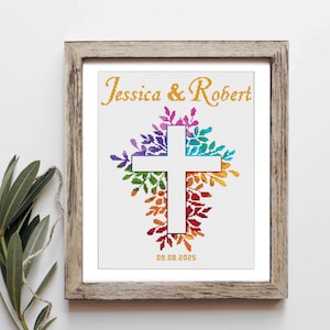 May include: A framed cross-stitch design with a white cross surrounded by colorful leaves. The names Jessica & Robert and the date 09.08.2025 are embroidered below the cross.