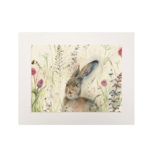 May include: A watercolor painting of a brown hare sitting in a field of wildflowers. The hare is looking to the left of the image, and the flowers are in shades of pink, purple, and white.