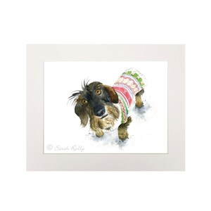 May include: A watercolor painting of a dachshund wearing a red, green, and white patterned sweater. The dog is looking up at the viewer with a curious expression.