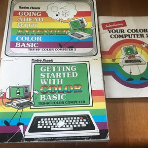 May include: Three vintage Radio Shack TRS-80 Color Computer manuals. The top left book is titled Going Ahead With Extended Color Basic. The bottom left book is Getting Started With Color Basic. The right book is Introducing Your Color Computer 2.