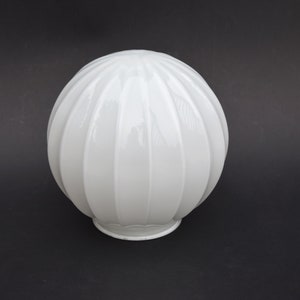 May include: A white, ribbed glass globe light fitting. The spherical shade has vertical grooves and a small, decorative base. The light fitting is a classic design, suitable for various interior styles.