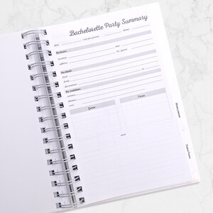 May include: Open spiral-bound notebook with a "Bachelorette Party Summary" page. The page includes sections for date, location, food, decorations, and more. The notebook is open on a white marble surface.