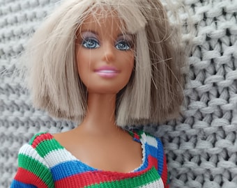 Vintage early 200's Barbie wearing a vintage MOD outfit from the 1970's - striped top, pocketed red skirt and go-go boots