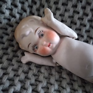 Antique porcelain bisque 4-inch-tall girl doll with articulated arms marked 161 Germany