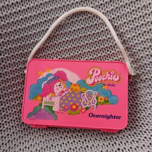Estojo Vintage Poochie para Meninas Overnighter - Bolsa de plástico rosa de 4" x 6" com alça de cadarço c. 1982