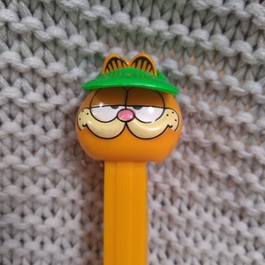 Vintage smiling Garfield the Cat in a green baseball cap PEZ dispenser