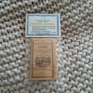 May include: A miniature replica of the 1853 Farmer's Almanac, a small brown booklet with the title "Farmer's Almanac 1853;" printed on the front cover. The booklet is packaged in a clear plastic bag with a white card that reads "Collectors Miniature 1853 Edition FARMER'S ALMANAC Our version of the antique rare edition. 48 pages filled with information and advice. May be read with magnifying glass. For mini scenes, curio collectors, etc. 1981 Merrimack Publ. Corp, 85 Fifth Ave, N.Y. 10003 No. 10622 Printed in Hong Kong"