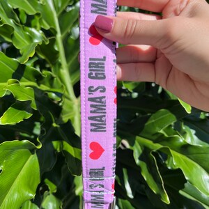May include: Purple fabric dog collar with the text "Mama's Girl" and red hearts.