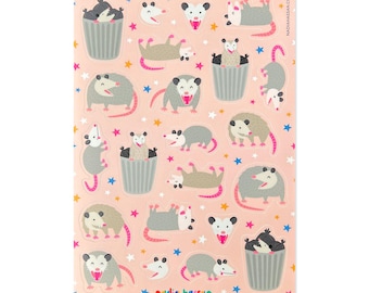Könnte beinhalten: Ein Stickerbogen mit Opossum-Illustrationen in verschiedenen Posen, darunter in Mülltonnen und liegend. Die Aufkleber sind grau, rosa und weiß, vor einem rosa Hintergrund mit Sternen. Der Text "NADIAHASSAN.COM" ist sichtbar.
