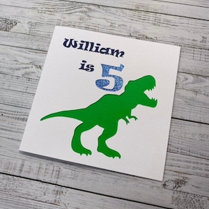 Biglietto di auguri di compleanno con dinosauro T-Rex con nome ed età per figlio, nipote o nipote - Messaggio personalizzato all'interno - Topper per torta abbinato disponibile