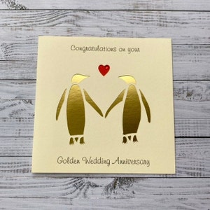 Tarjeta personalizada para el 50.° aniversario de bodas de oro con una pareja de pingüinos en dorado brillante: una tarjeta de papel recortado especial y única, hecha a mano por encargo