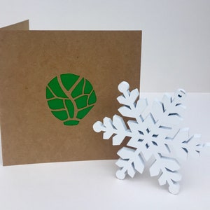 Biglietto di auguri di Natale con cavoletti di Bruxelles ritagliato in carta o biglietto casuale per qualcuno che ama o odia i cavoletti di Bruxelles. Interno vuoto.