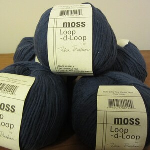May include: Four balls of navy blue yarn with white labels that read "moss Loop -d-Loop by Uon Durham". The labels also include the yarn composition: 80% Extra Fine Merino Wool 15% Nylon. Made in Italy. Exclusively for Stacy Charles.