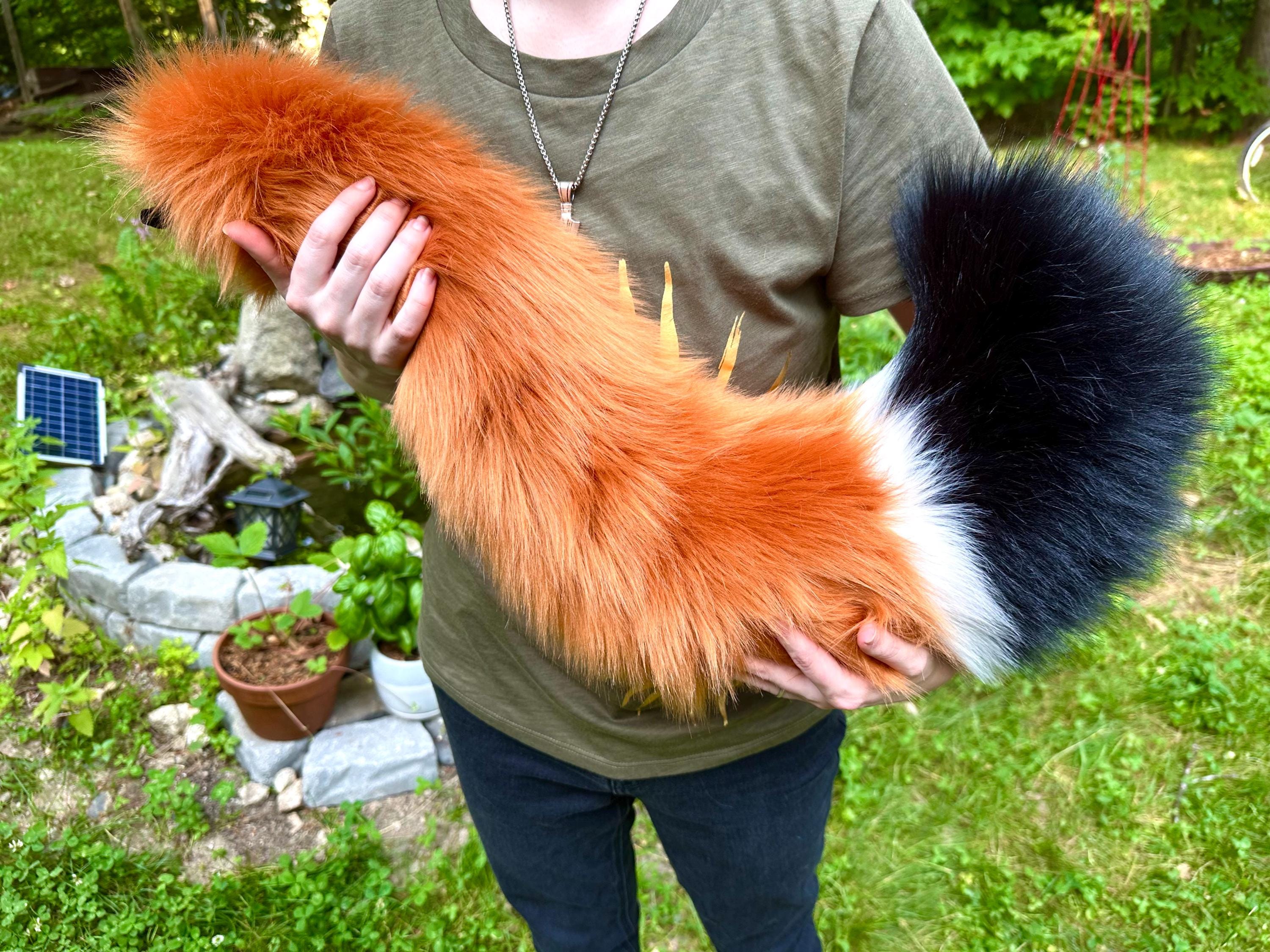 ふわふわの三色キツネのしっぽ - ぬいぐるみの毛皮のようなキツネの獣