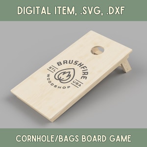 以下が含まれることがあります： 「Brushfire STL Woodshop USA」というロゴが入った木製のコーンホールゲームです。