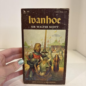 May include: Vintage paperback book titled "Ivanhoe" by Sir Walter Scott. The cover features an illustration of a knight on horseback, with text that reads "Complete and Unabridged". The book is part of the Classics Series.