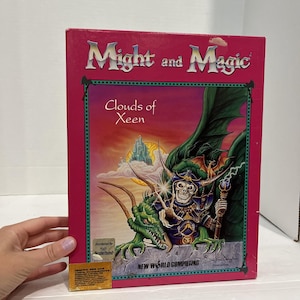 May include: A vintage video game box for "Might and Magic: Clouds of Xeen." The box features a fantasy illustration of a skeletal figure with a staff, a green dragon, and a castle. The box is red with the game title in silver.