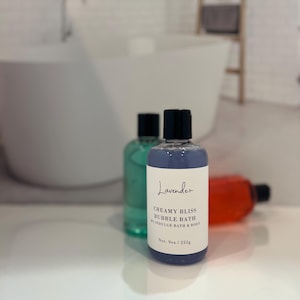 May include: A lavender-scented bubble bath bottle with a black cap. The bottle is labeled "Creamy Bliss Bubble Bath by Indulge Bath & Body" and "Net. 9oz / 255g".