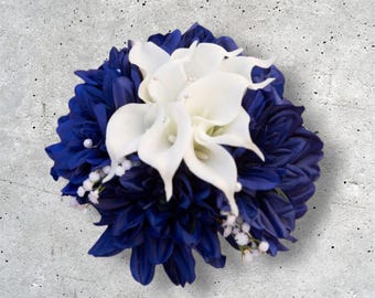 Puede incluir: Arreglo floral con una base de dalia azul oscuro, calas blancas y pequeñas flores blancas. El arreglo está adornado con pequeñas perlas. Ideal para bodas o eventos especiales.