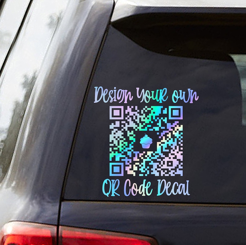 Pode incluir: Uma janela de carro com um adesivo hologr&aacute;fico que diz "Projete seu pr&oacute;prio adesivo de c&oacute;digo QR". O adesivo apresenta um c&oacute;digo QR colorido com um &iacute;cone de cupcake no centro.