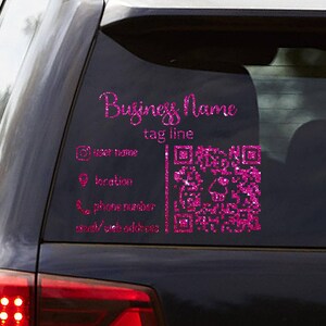 May include: A pink glitter decal applied to a car window. The decal includes the text "Business Name" and "tag line", along with social media icons and a QR code. The car is dark in color.