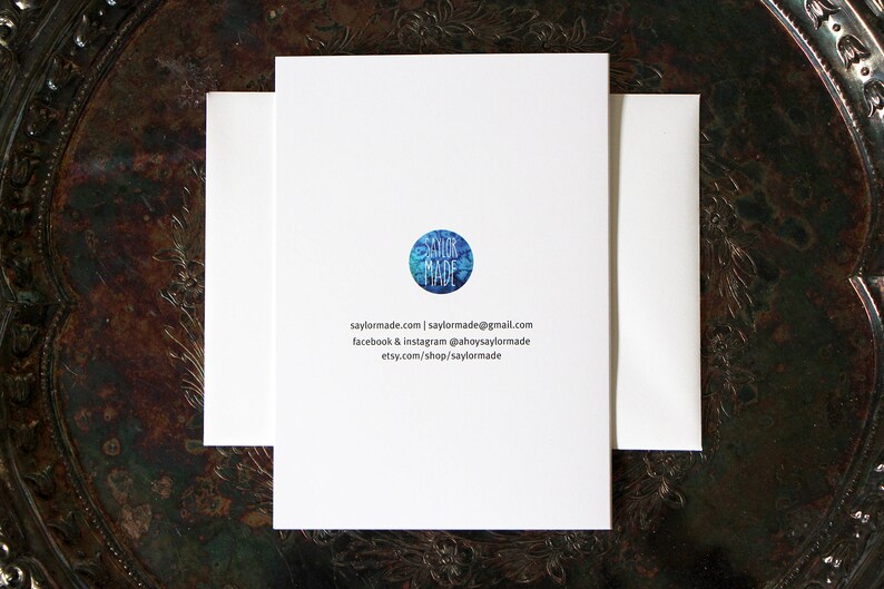 The back of the card displays the artists logo SaylorMade as well as social media and website contact information. These items are small in size and printed centred on the back.