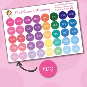 Puede incluir: Hoja de pegatinas de planificador coloridas con el texto "RDO" en una variedad de colores. Las pegatinas están dispuestas en un patrón de cuadrícula y presentan un logotipo con el texto "The Planner Mummy". El fondo es de color rosa claro.