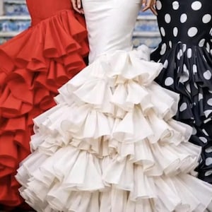 May include: Three floor-length dresses featuring fitted bodices and voluminous skirts with multiple layers of cascading ruffles. One dress is solid red, one is solid white, and one is black with a white polka dot pattern on the bodice and skirt.