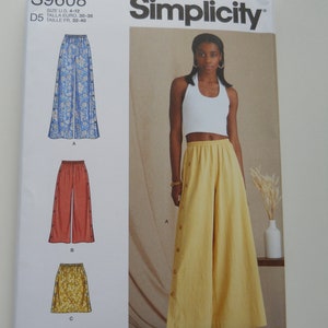 May include: Simplicity sewing pattern number S9608 for wide-leg pants. The pattern includes three different styles: a pair of blue and white floral pants, a pair of red pants, and a yellow skirt. The pattern is labeled "easy-to-sew" and is designed and printed in the USA.