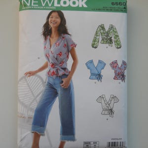May include: A New Look sewing pattern packet, featuring a woman in a wrap top and jeans. The packet includes illustrations of different wrap top designs. The text "NEW LOOK" is at the top.