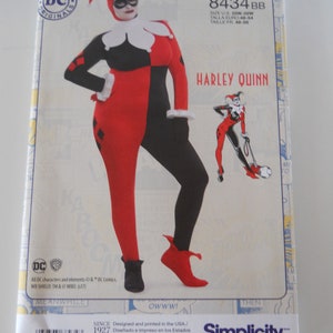 May include: A sewing pattern for a Harley Quinn costume. The pattern is for sizes 20W-28W and includes instructions for making a red and black jester costume with a white collar and a black mask. The pattern is from Simplicity and is designed and printed in the USA.